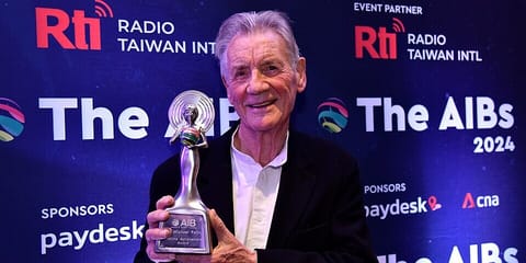 Sir Michael Palin holding his Lifetime Achievement award at the AIBs
